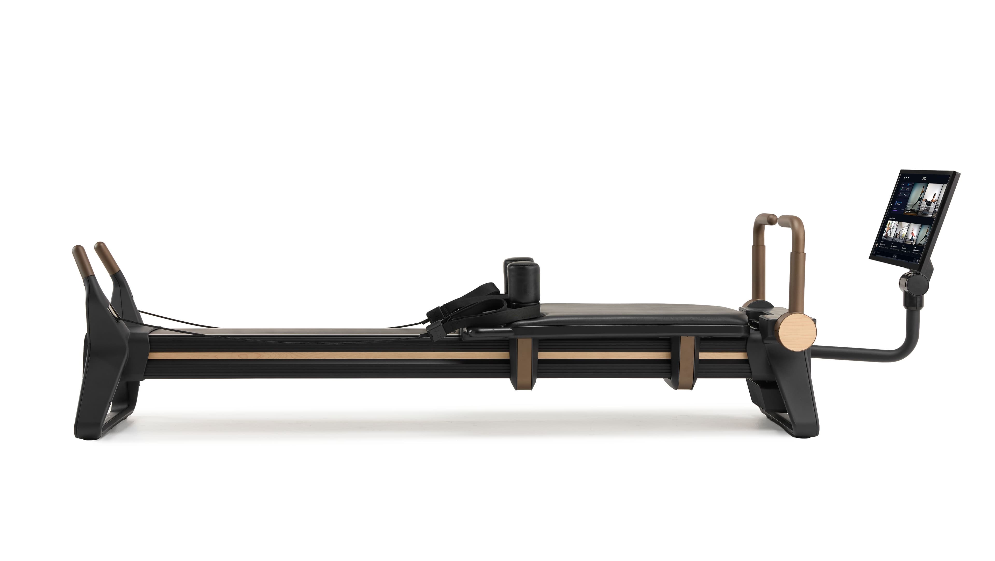 NordicTrack Ultra 1 Reformer with a wood finish and touchscreen, wrapped with a gold bow.