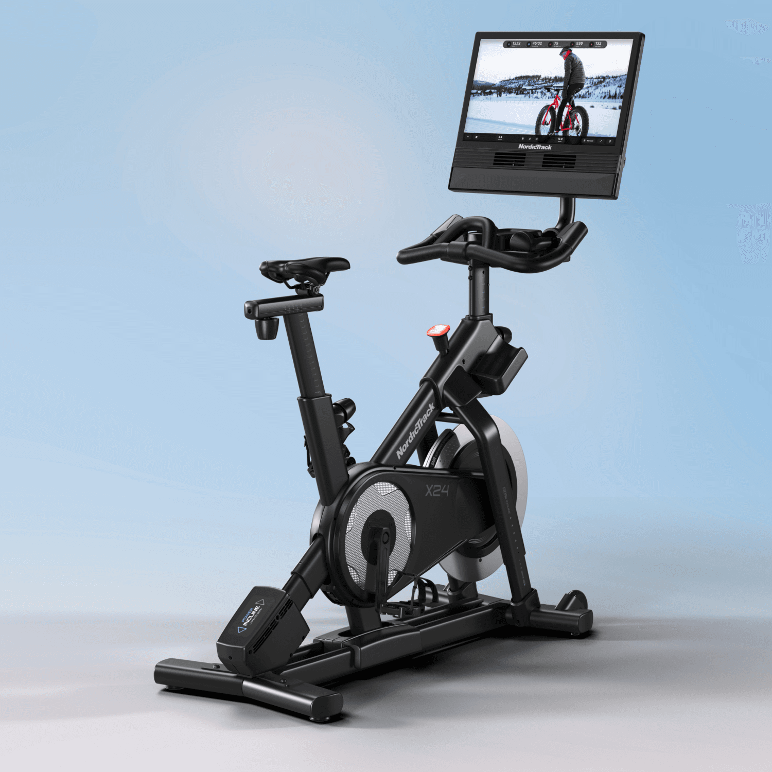 The X24 Studio Bike against a blue backdrop showcasing winter workout content on its 24" touchscreen.