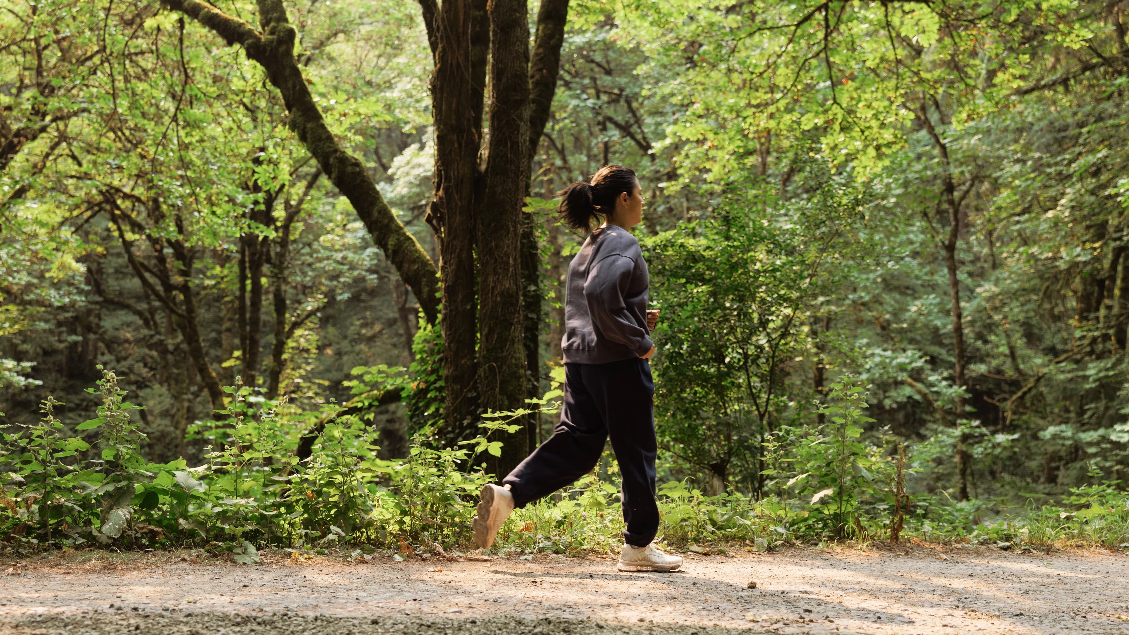 A runner takes on a shaded forest trail in Portland, Oregon, the kind of real-world terrain iFIT's outdoor workouts are filmed on location to recreate.