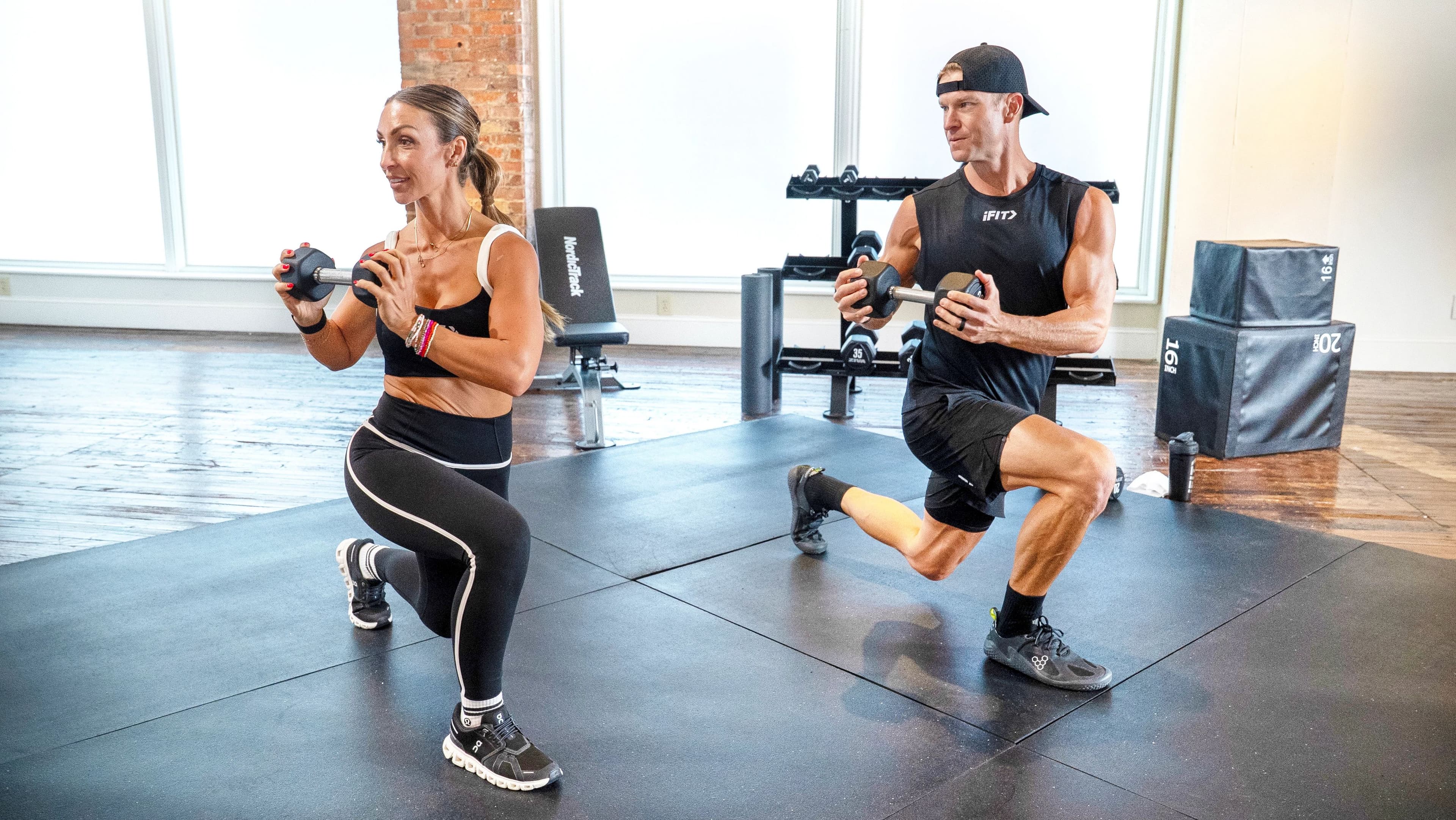 iFIT Trainers Bree Cox and John Peel lead a dumbbell lunge strength session, the kind of trainer-led coaching included with an iFIT Pro membership.