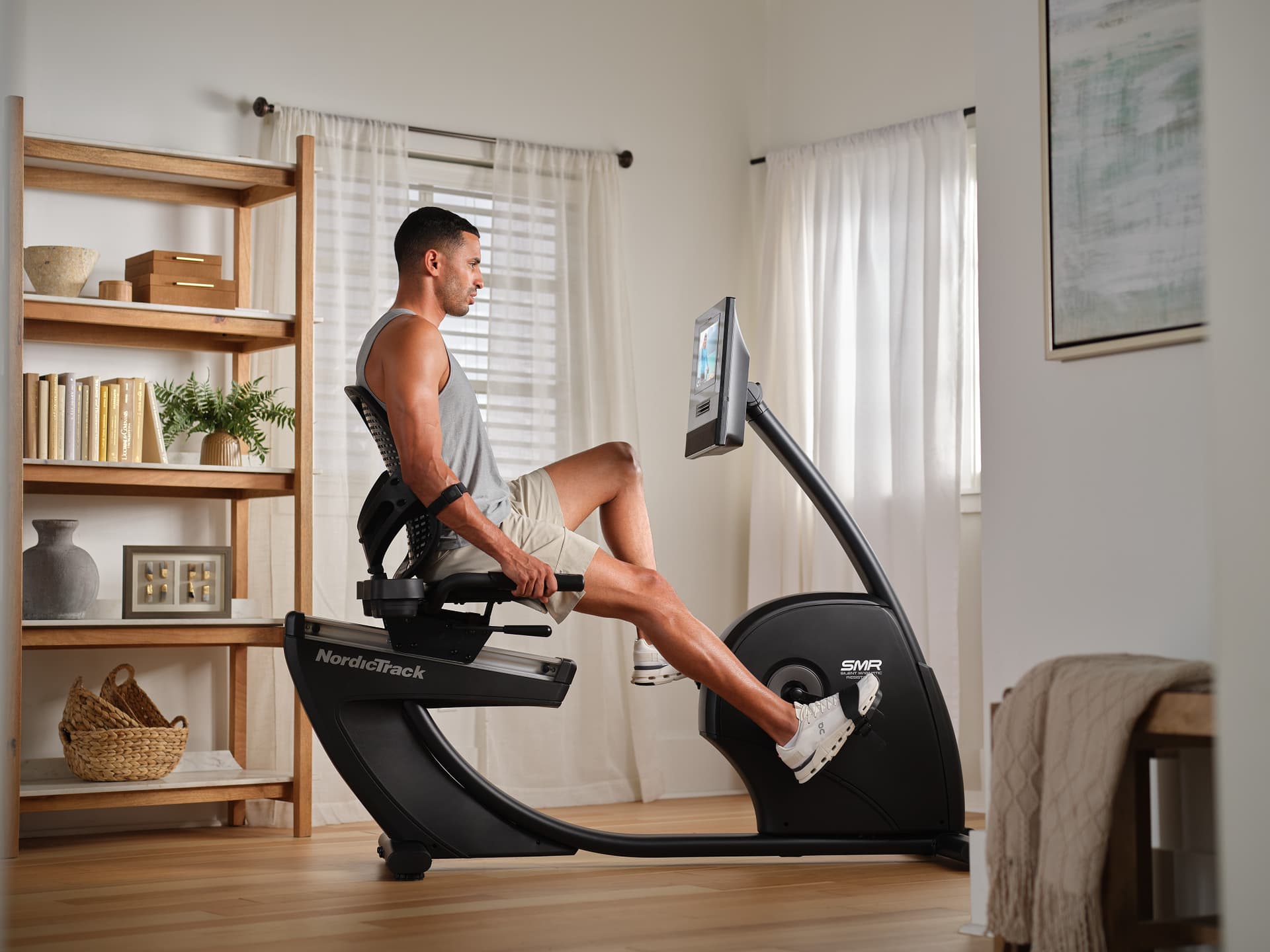 Homme pédalant sur le vélo d'appartement semi-allongé NordicTrack 10 pendant une séance d'entraînement à domicile.