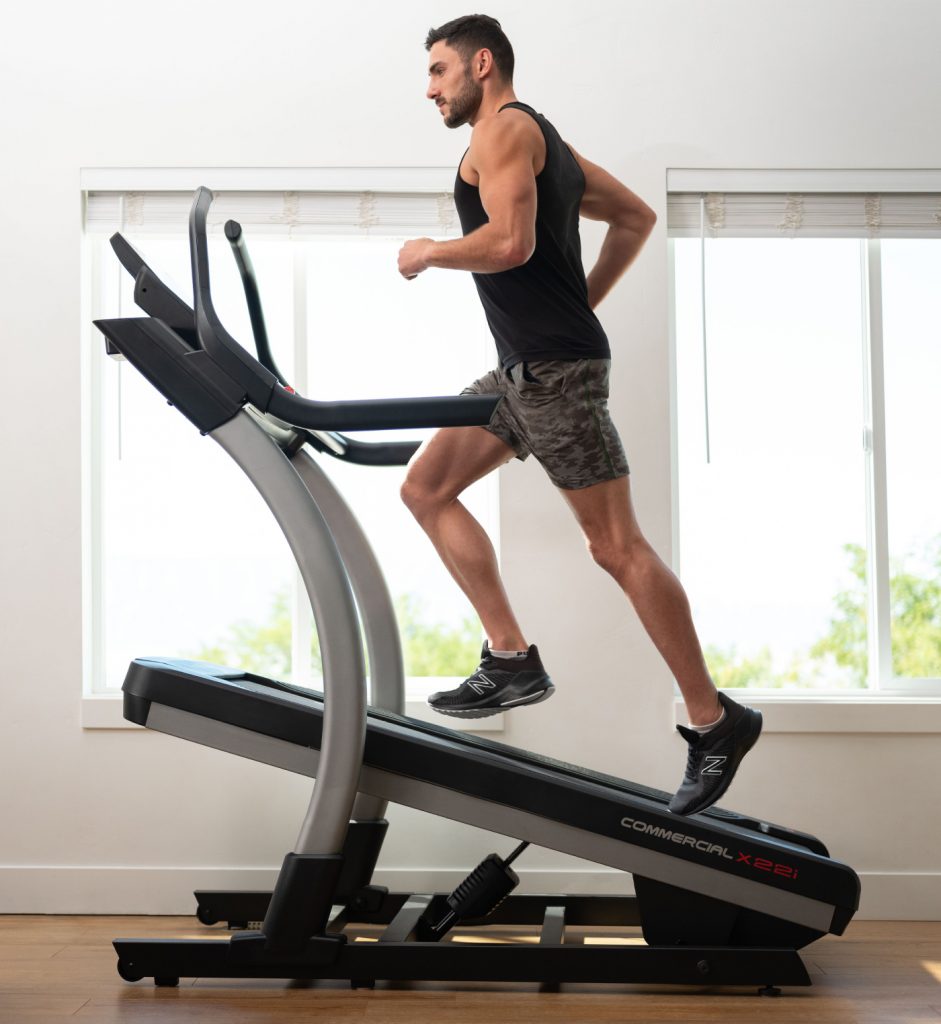 Man runs on an incline treadmill during his at-home workout