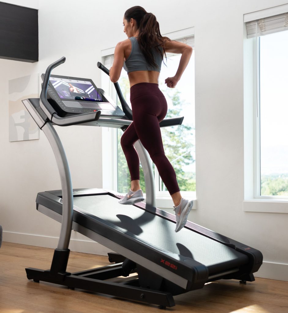 Woman runs on an incline treadmill during her at-home workout