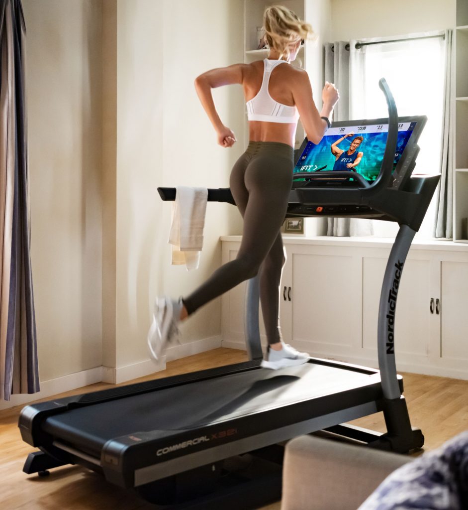 Woman runs on a high incline treadmill in her home gym