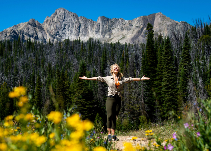 How Does Nature Benefit Out Health? Woman Stands Outside in Nature Enjoying All It Has to Offer