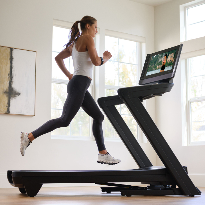 Woman Running on a NordicTrack Treadmill to Maximize and Support Her Calorie Burn