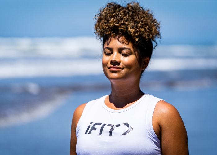 iFIT  Trainer Meditating on a Beach and Practicing Relaxation and Stress-Reducing Techniques