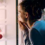Woman Looking Into a Fridge Late At Night for the Article How to Curb After Dinner Cravings